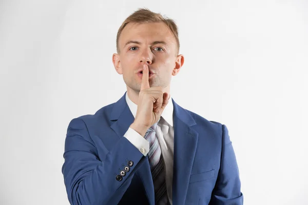 Businessman with finger over lips — Stock Photo, Image