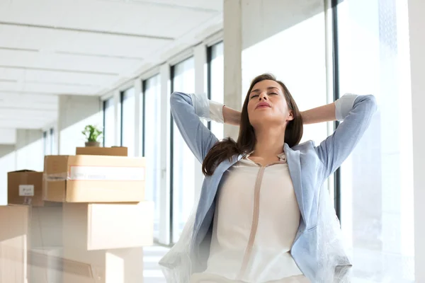 Mujer de negocios relajada con las manos detrás de la cabeza — Foto de Stock