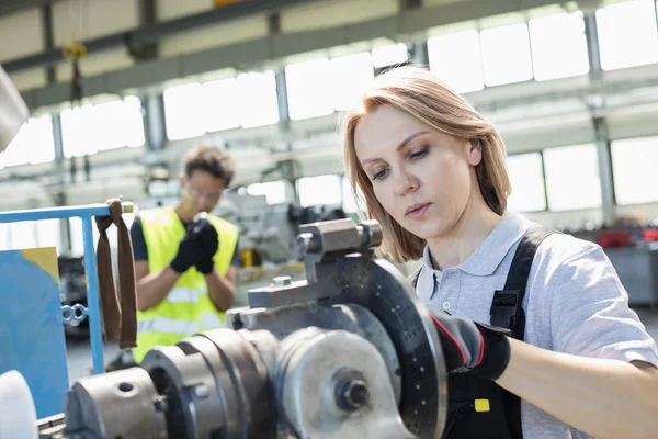 Vrouwelijke werknemer die in de industrie aan machines werkt — Stockfoto