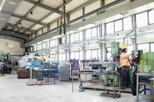 Arbetstagaren använder maskiner i metallindustrin — Stockfoto