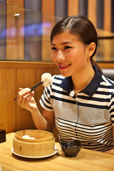 Kvinnan äter ångad dumpling — Stockfoto