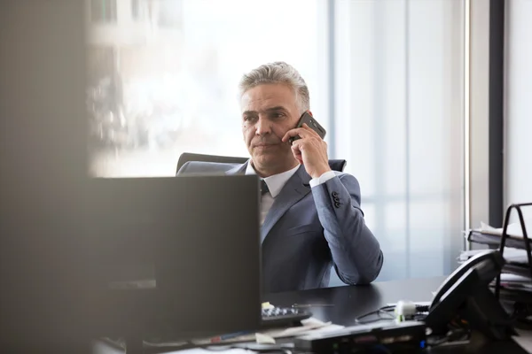 Mature businessman talking on mobile phone — Stock Photo, Image