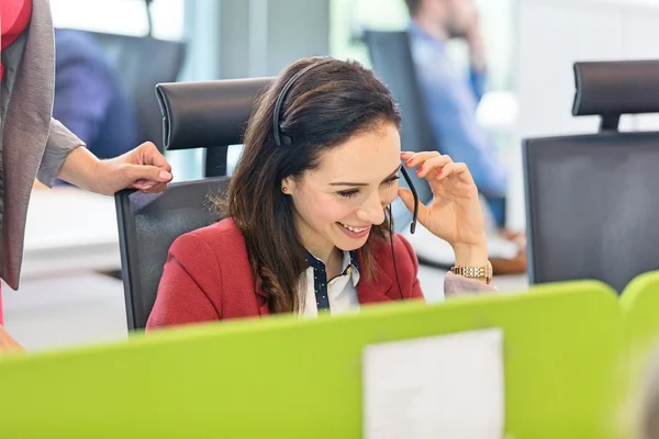 Usměvavá moderátorka pomocí headsetu v úřadu — Stock fotografie