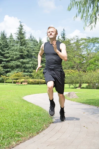 Uomo in forma che corre nel parco — Foto Stock