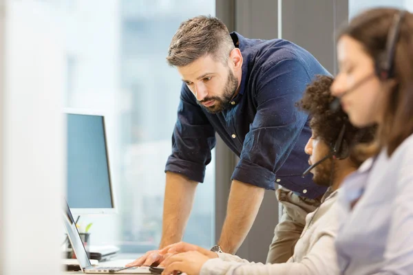 Zakenman met collega 's in functie — Stockfoto