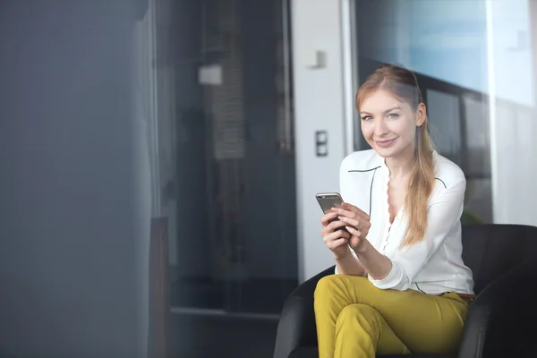 Podnikatelka, používající mobilní telefon v kanceláři — Stock fotografie