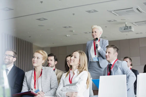 Businesswoman asking questions during seminar — Stock Photo, Image