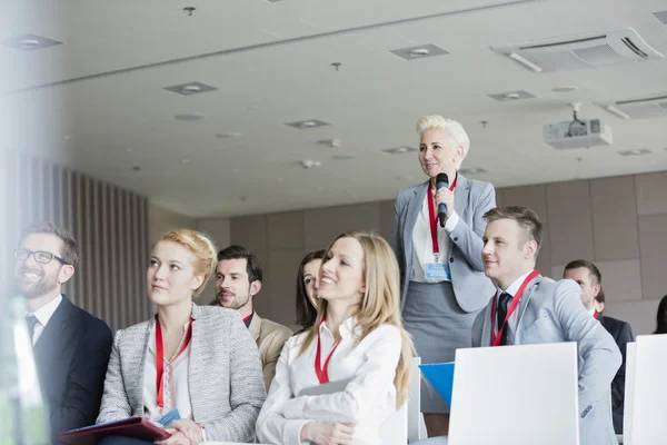 Affärskvinna ställa frågor under seminarium — Stockfoto