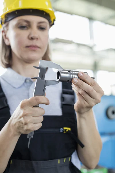 Trabajador que mide metal con pinza en fábrica — Foto de Stock