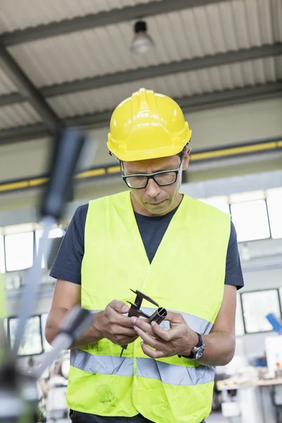 Werknemer meten van metaal met remklauw in industrie — Stockfoto