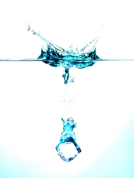 Ice cube splashing into water — Stock Photo, Image