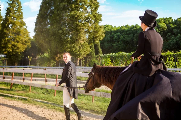 Hombre tirando de la mujer sentado a caballo —  Fotos de Stock