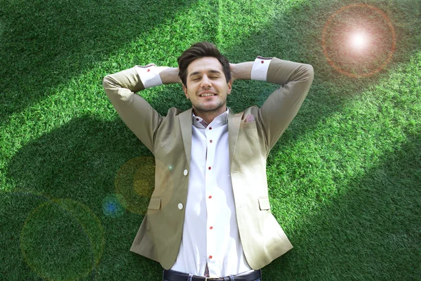 Uvolněné mladý podnikatel ležící na trávníku — Stock fotografie