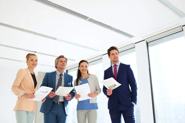 Glimlachende zakenmensen met documenten in office — Stockfoto