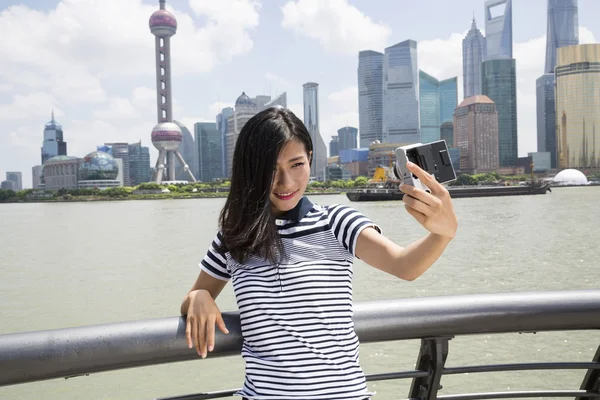 浦東のスカイラインに対して selfie を取る女性 ストックフォト