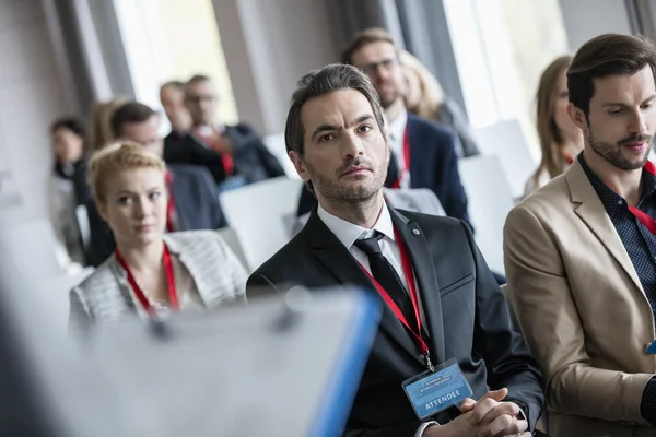 Businessman listening to presentation during seminar — Stock Image Businessman listening to presentation during seminar Stock Image