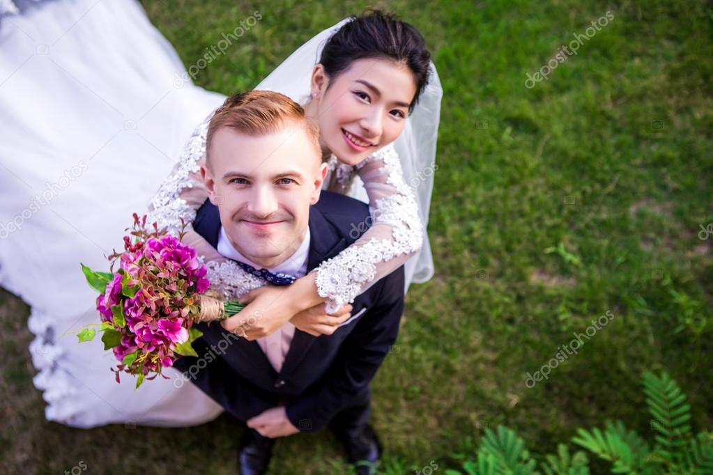 Happy wedding couple standing on field