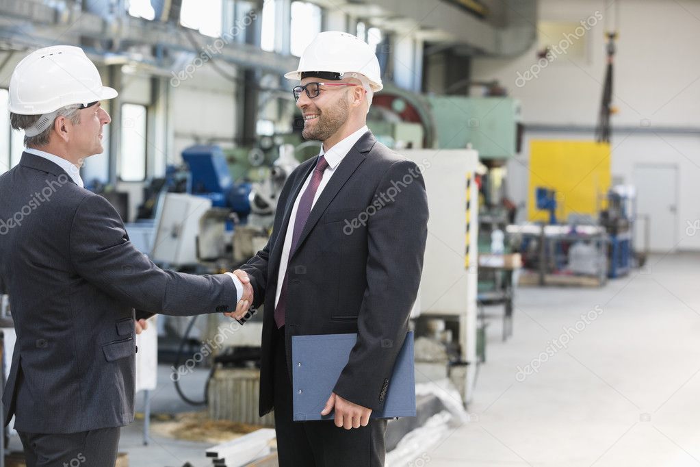 Businessmen shaking hands in metal industry 