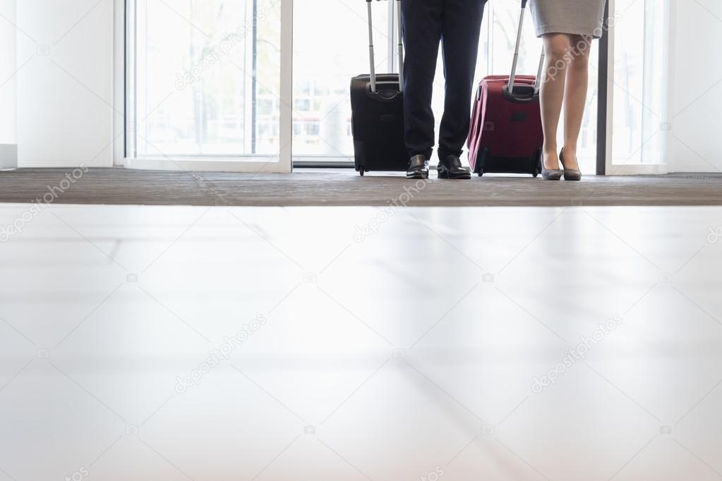 Business people with luggages at doorway