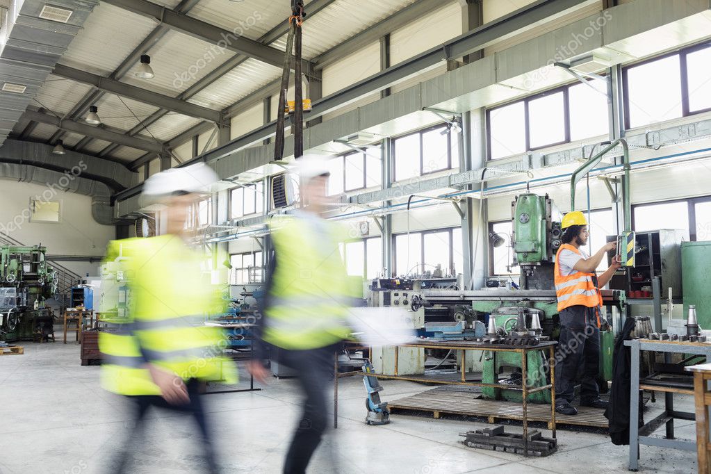 Business people with manual worker at industry 