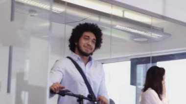 Ofise gelen bisiklet üzerinde mutlu iş adamı 