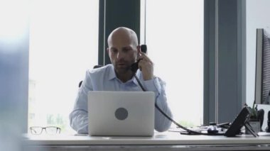 Ciddi kel ofisinde çalışan iş adamı 