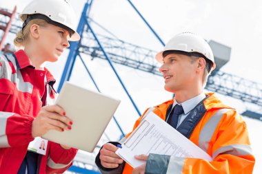 Tablet bilgisayar üzerinde tartışırken işçi 