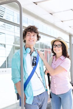 Gülümseyen çift bekleyen otobüs durağında