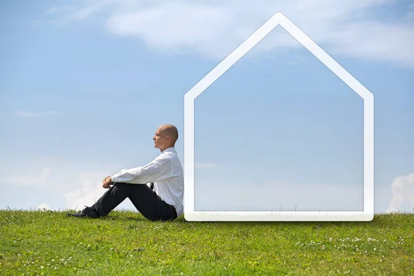 Uomo d'affari contemplando a simbolo di casa — Foto Stock