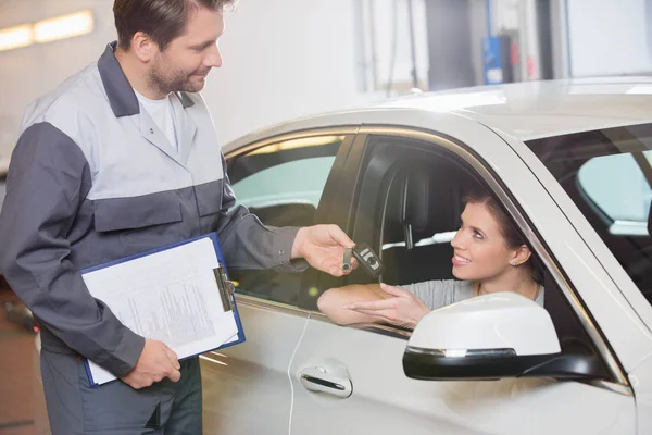 Mecânico dando a chave do carro ao cliente — Fotografia de Stock