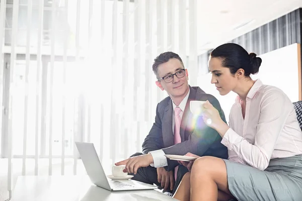 Affärsmannen och affärskvinna diskuterar över laptop — Stockfoto