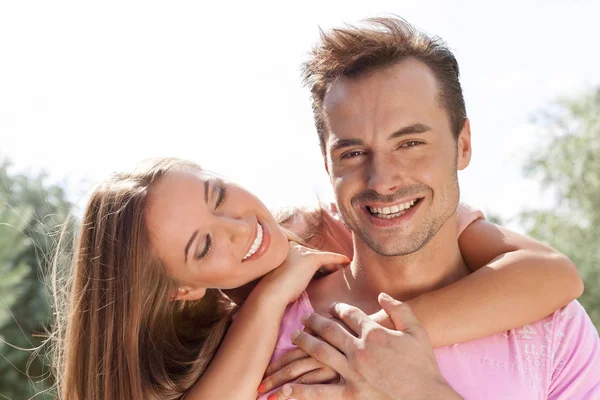 Mujer joven sonriente abrazando al hombre —  Fotos de Stock