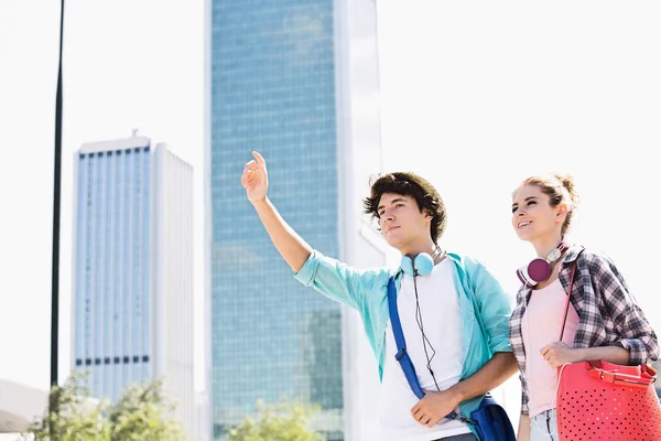 Happy friends hailing a taxi — Stock Photo, Image