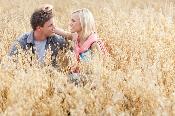 Couple relaxing amidst field — Stock Photo, Image