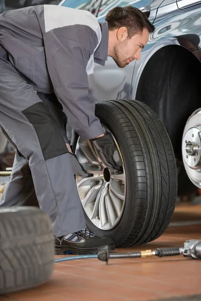 Mechanic fixing car's tire — Stock Photo, Image