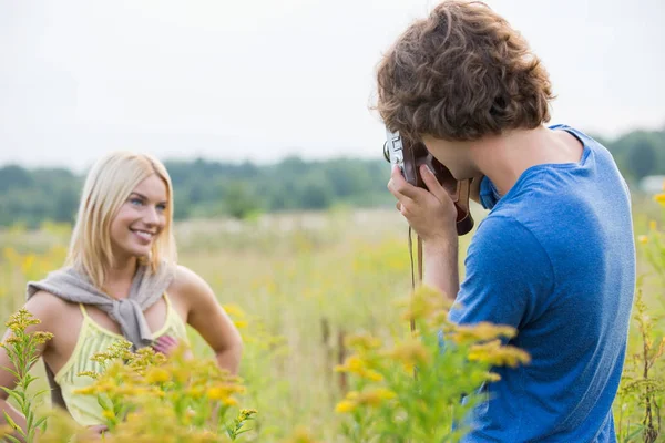 Fotograferen vriendin van de man op gebied — Stockfoto