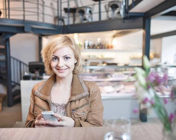 Jonge vrouw met mobiele telefoon — Stockfoto