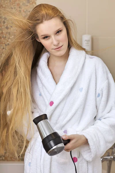 Mulher usando um secador de cabelo — Fotografia de Stock