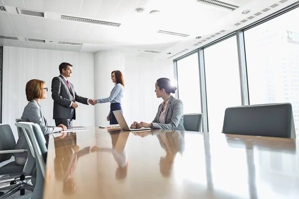 Empresario y empresaria estrechando la mano — Foto de Stock