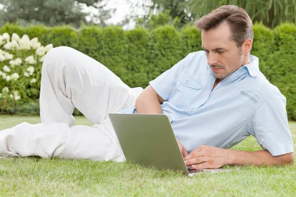 Man använder laptop i park — Stockfoto