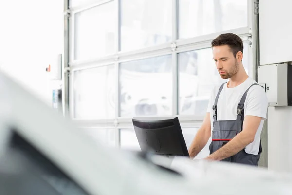 Mecânico de automóveis usando computador — Fotografia de Stock