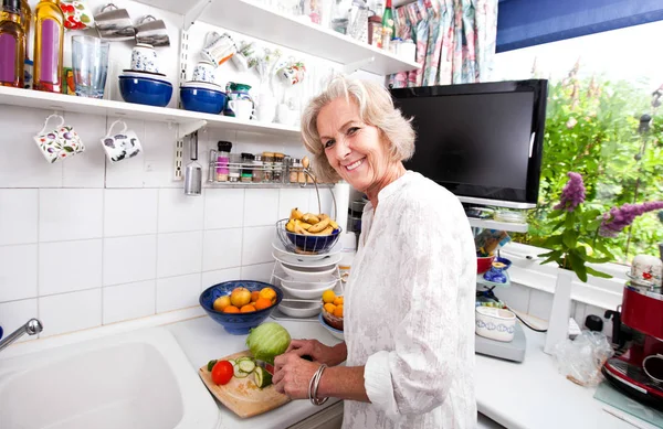 Mulher sênior corte de legumes — Fotografia de Stock