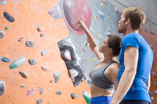 Friends discussing by climbing wall