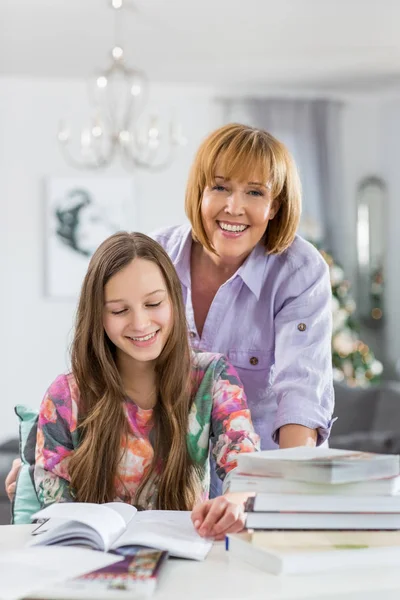 Moeder dochter in het huiswerk helpen — Stockfoto