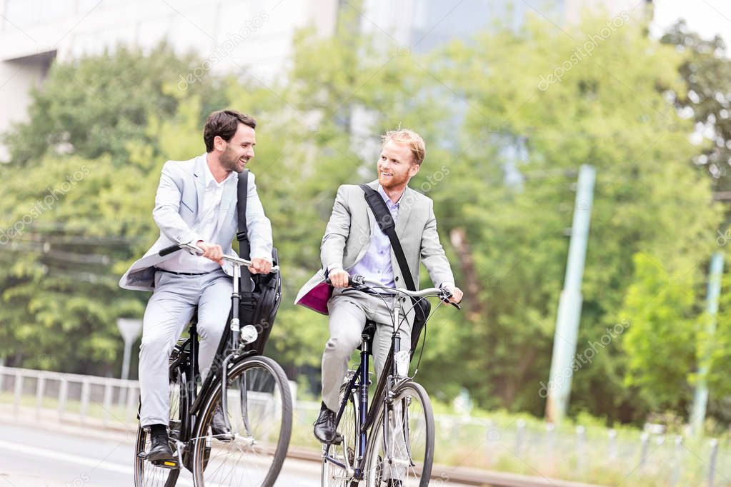 Businessmen talking while cycling 