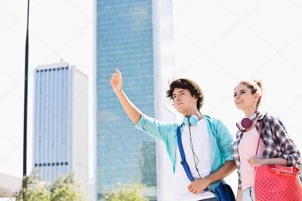 Happy friends hailing a taxi