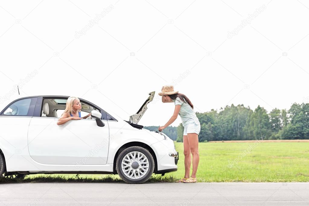 Women at car on country road