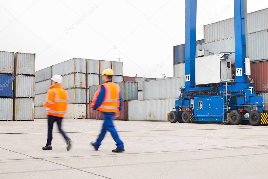 Workers walking in shipping yard