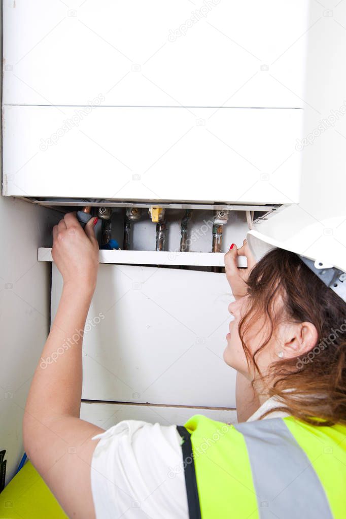 plumber servicing central heating boiler