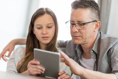 Father and daughter using digital tablet  clipart